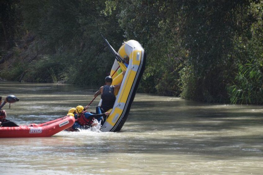A person in a yellow and white inflatable raft being flipped over by another raft. 5
