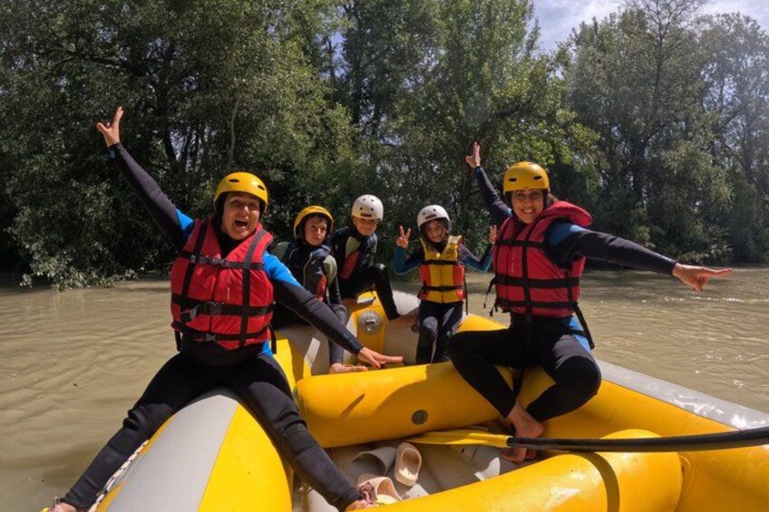 People in a yellow raft on a river surrounded by trees. 3