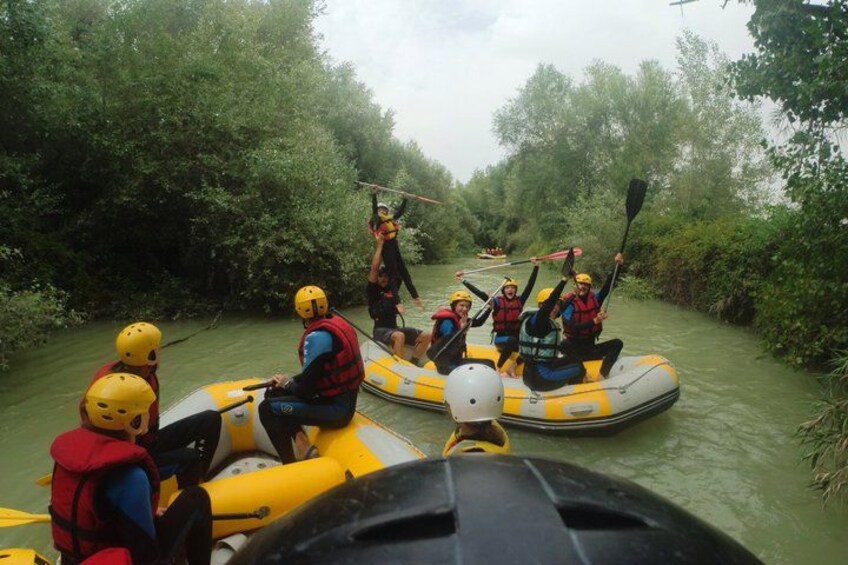 A group of people in inflatable rafts on a river surrounded by dense greenery. 5