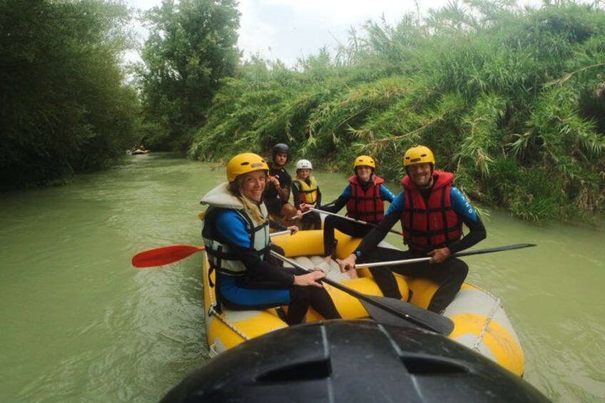 A group of people in a yellow raft navigating a river surrounded by dense greenery. 4