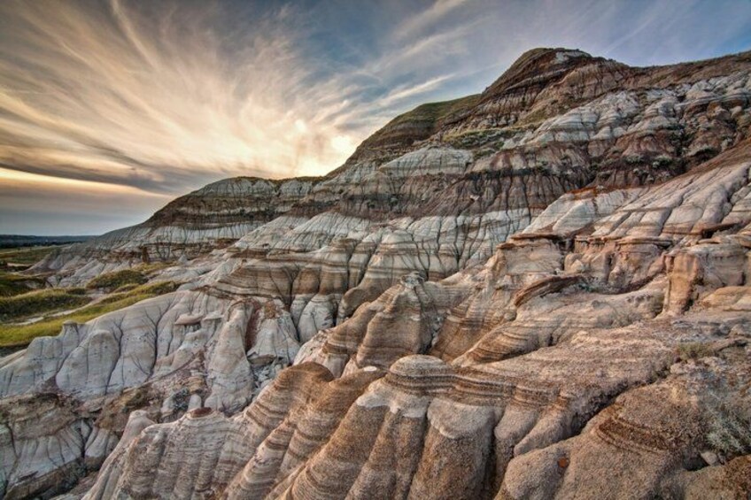 A landscape with layered rock formations and a cloudy sky. 4