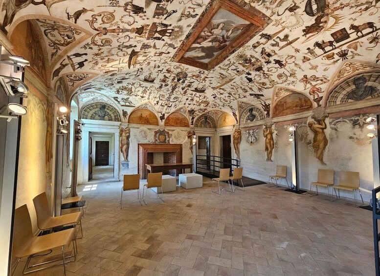 Un amplio salón con techo alto decorado con frescos detallados y un cuadro central. 2