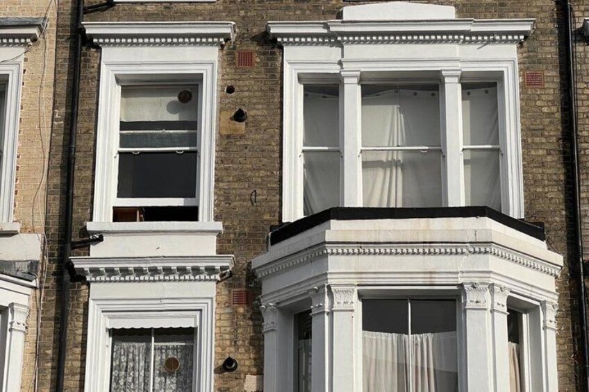 A row of Victorian-style buildings with bay windows and ornate detailing. 4