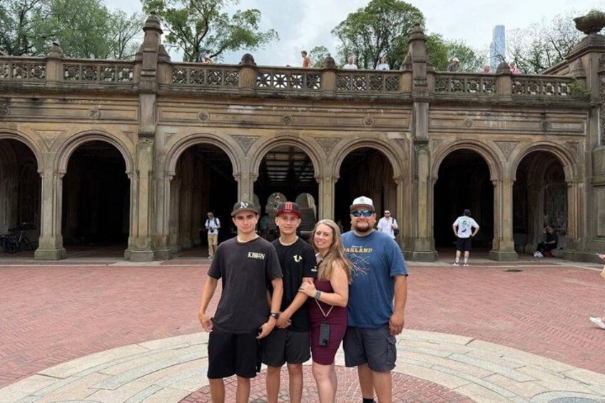 A group of people standing in front of a historic stone building with arches. 5