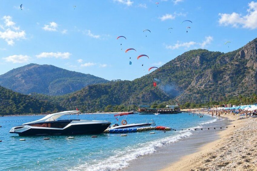 A beach with boats, a pier, and people. 2