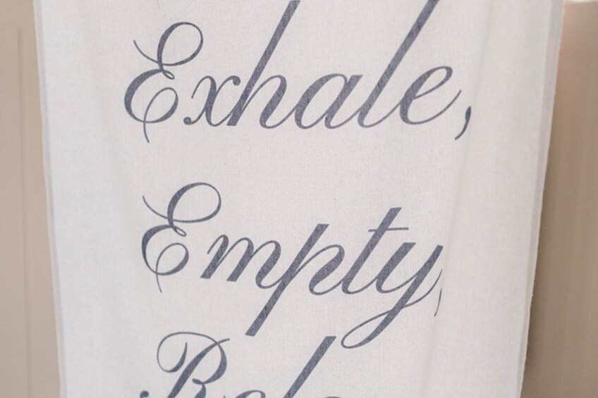 A sign with the words 'Exhale, Empty, Relax' in cursive script. 4