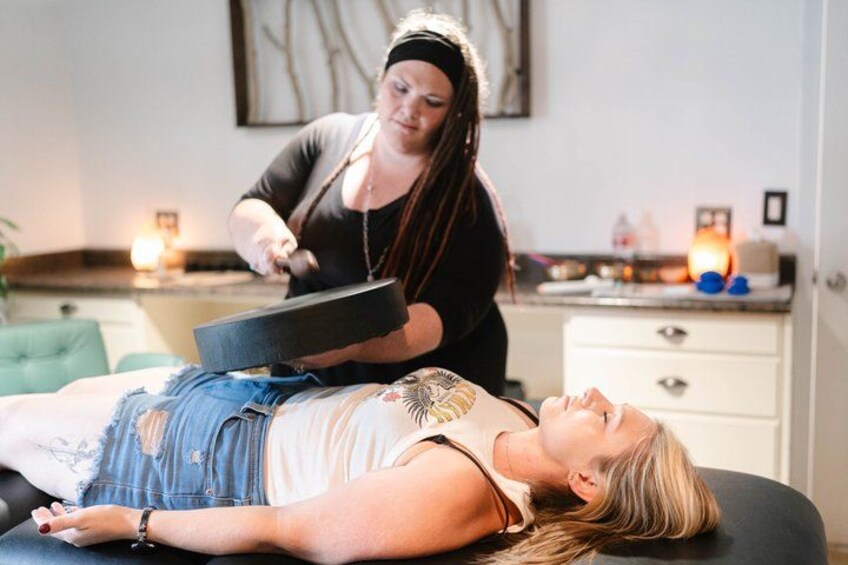 A person lying on a massage table receiving a treatment. 1