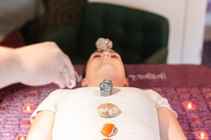 A person lying down with a massage therapist's hand applying pressure to their back. 3