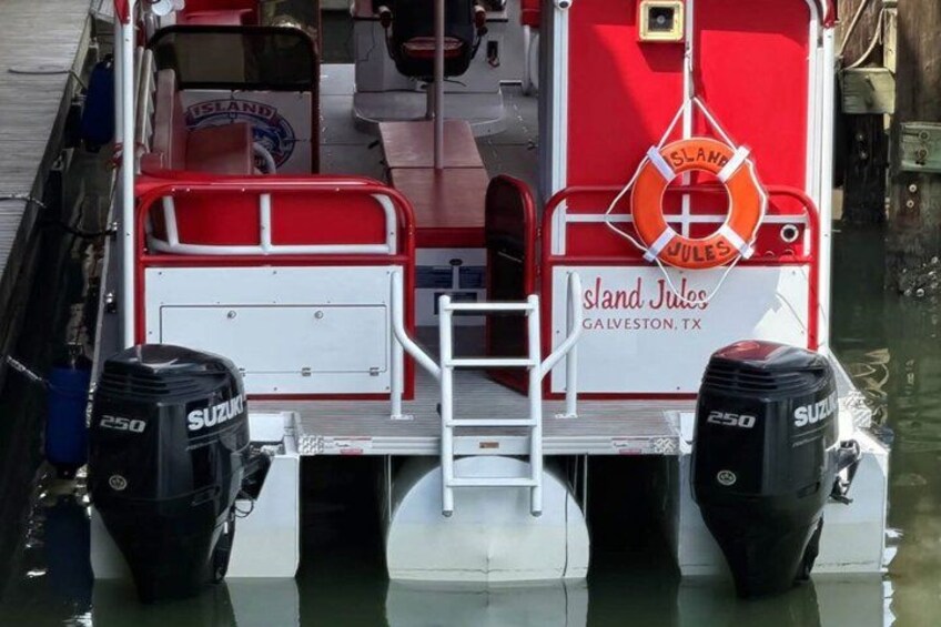 A red and white boat named 'Island Jules' with two Suzuki outboard motors, docked at a pier. 4