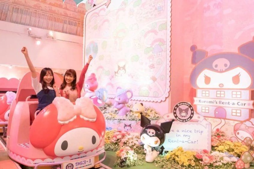 A pink ride with a Hello Kitty character, surrounded by plush toys and a sign that reads 'Kurumi's Rent-a-Car.' 3