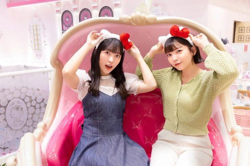 Two individuals in a pink chair with a decorative headband, surrounded by a pink and white interior. 4