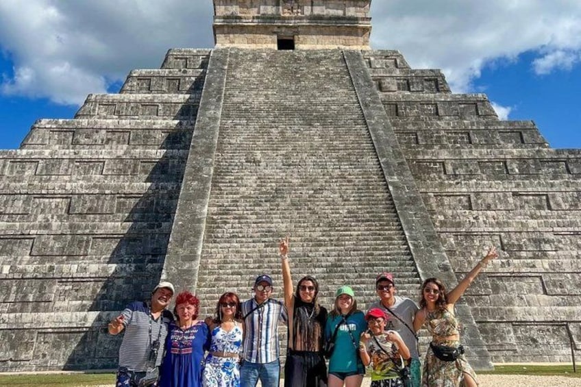 A group of people standing in front of a large ancient pyramid. 4