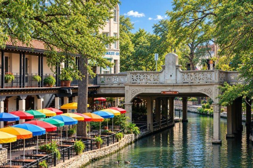 A canal with a bridge, colorful umbrellas, and buildings with balconies. 5
