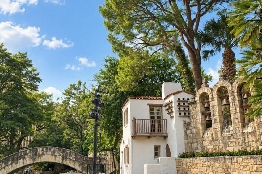A stone bridge, white building with balconies, and a stone wall with arches. 3