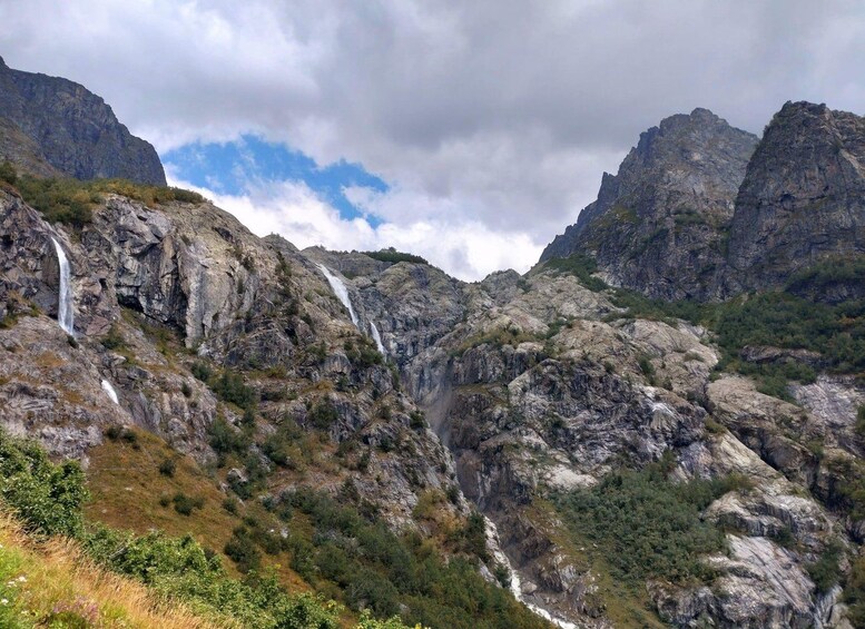 Un paisaje montañoso con varias cascadas que se precipitan por riscos escarpados. 1