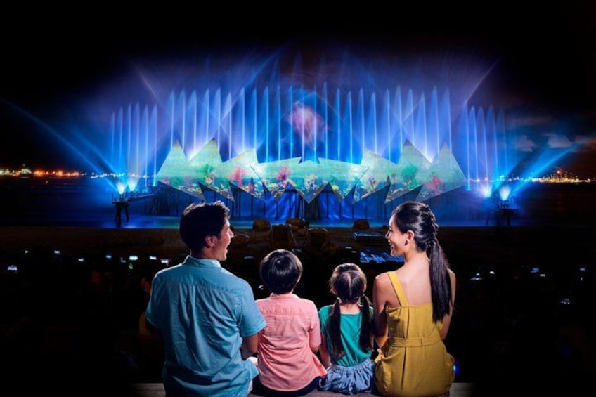 A family watching a fountain show with water jets and lights. 3
