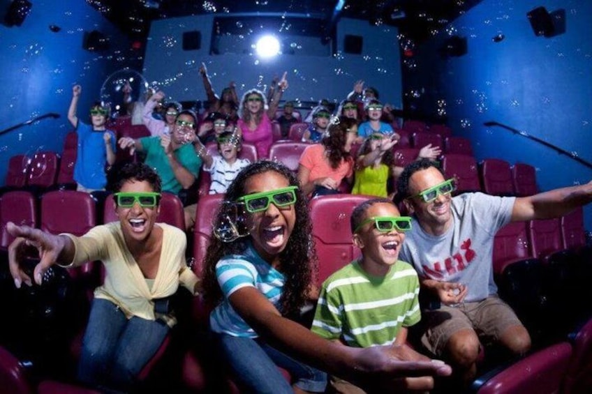 People in a movie theater with red seats and a blue ceiling. 3