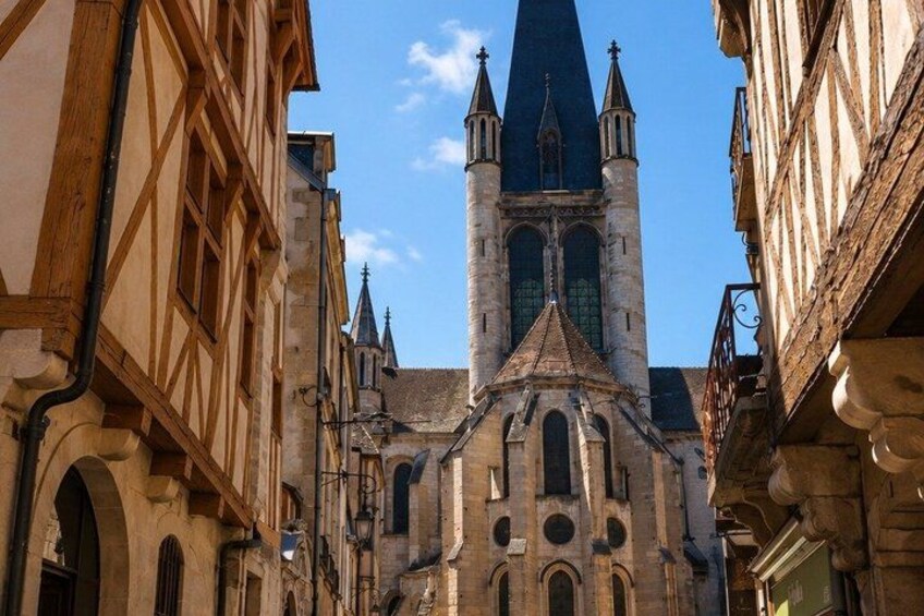 A historic church with a tall spire and multiple towers, surrounded by traditional half-timbered buildings. 3