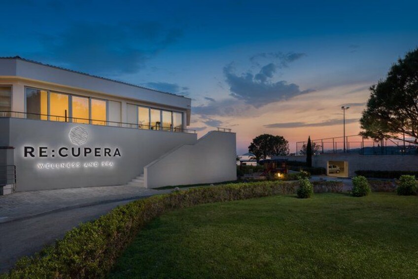 A modern building with the sign RE:CUPERA WELLNESS AND SPA. 3