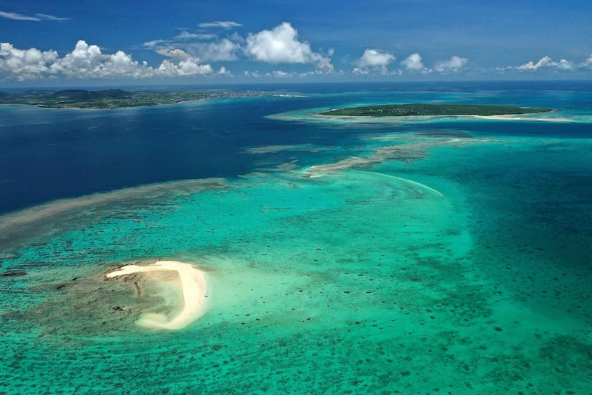 A turquoise coral reef with clear waters and a sandy beach. 2