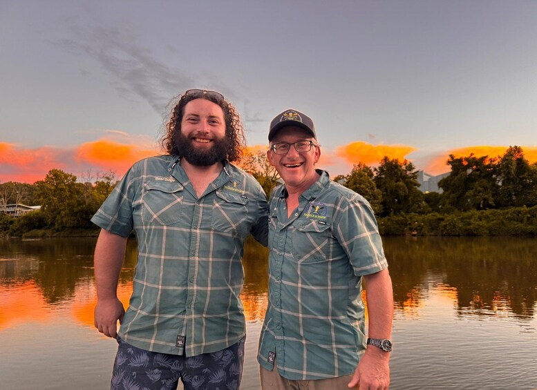 Two people standing by a lake with a sunset in the background. 5