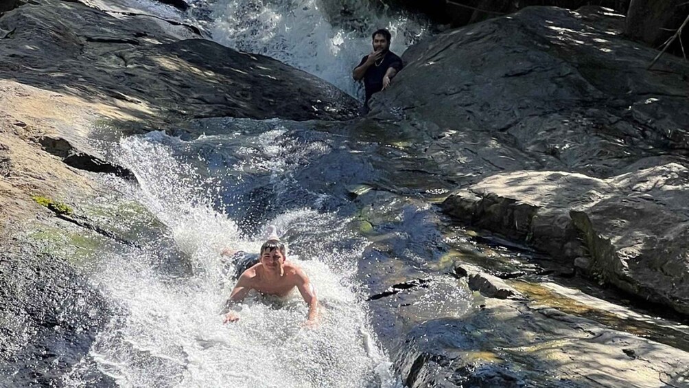 Una persona surfeando una ola en un río rocoso. 2