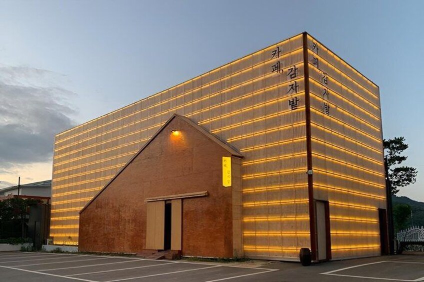 A modern building with a sloped roof and illuminated facade. 5