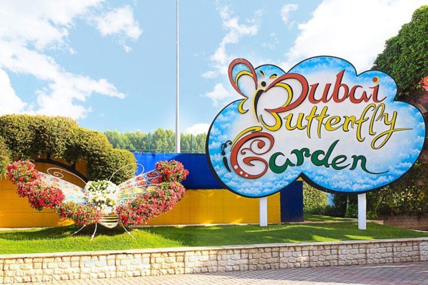 A sign for the Dubai Butterfly Garden with a butterfly sculpture. 1