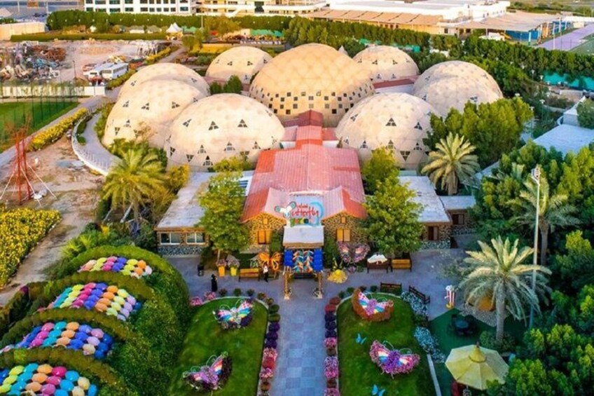 A large building with multiple dome-shaped structures, surrounded by landscaped gardens and colorful flower arrangements. 4