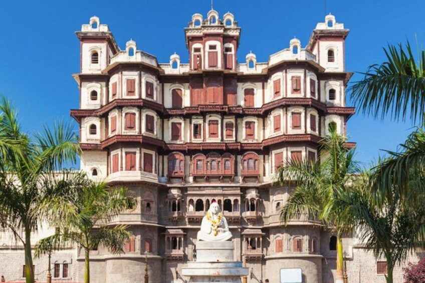 A large, ornate building with multiple balconies and a statue in front. 4
