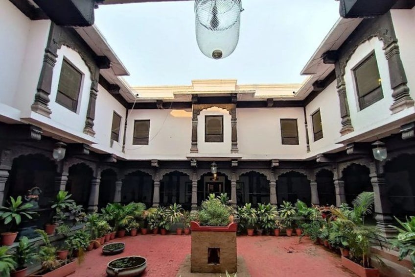 A courtyard with a central fountain, surrounded by arches and potted plants. 2