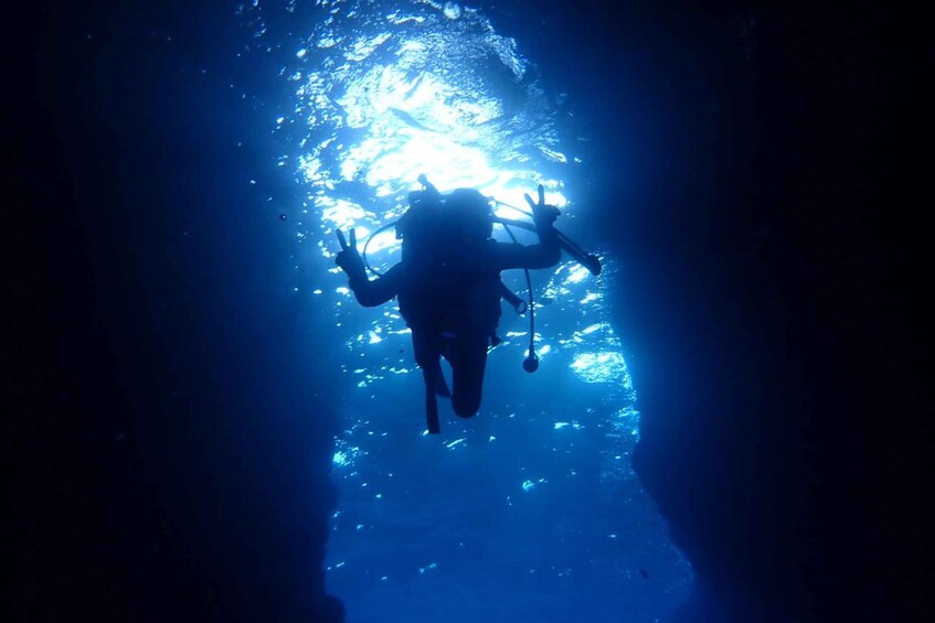Un buceador en una cueva con una fuente de luz en la parte superior. 4