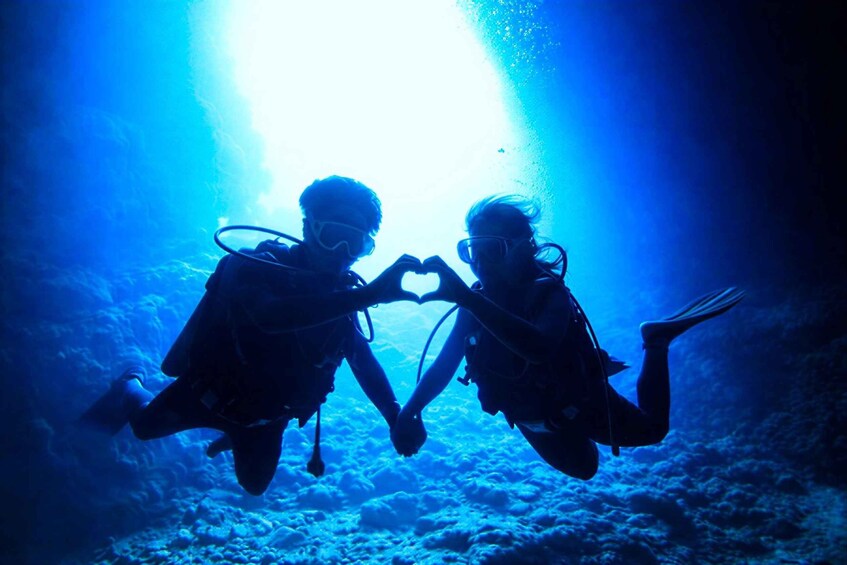 Dos buzos haciendo la forma de un corazón bajo el agua. 5