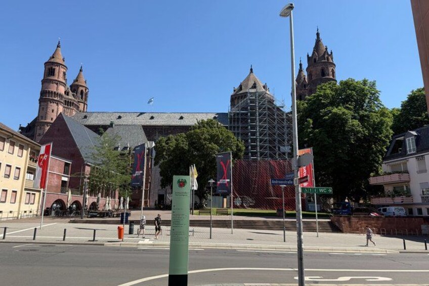 A city square with historic buildings, a pedestrian crossing, and street signs. 3