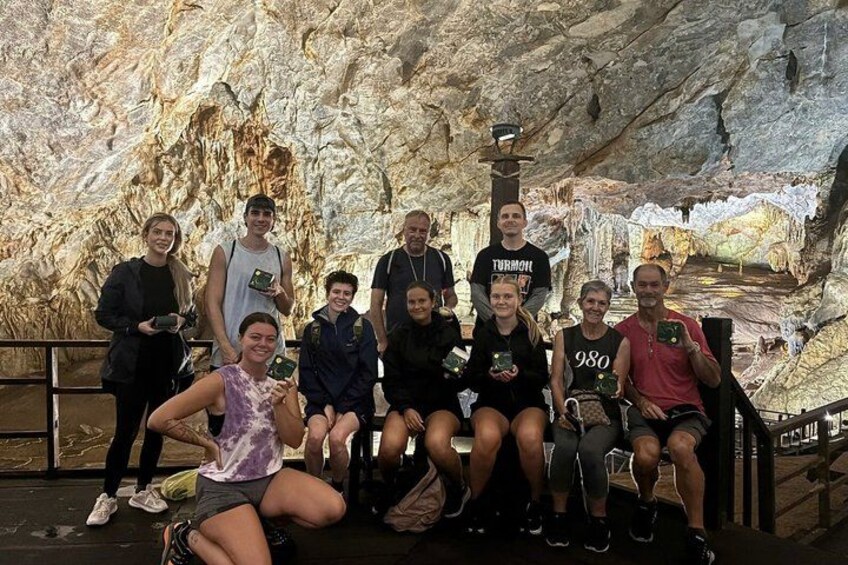 A group of people in a cave with stalactites and stalagmites. 4