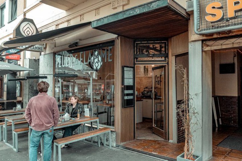 A café with outdoor seating and a visible menu board. 1