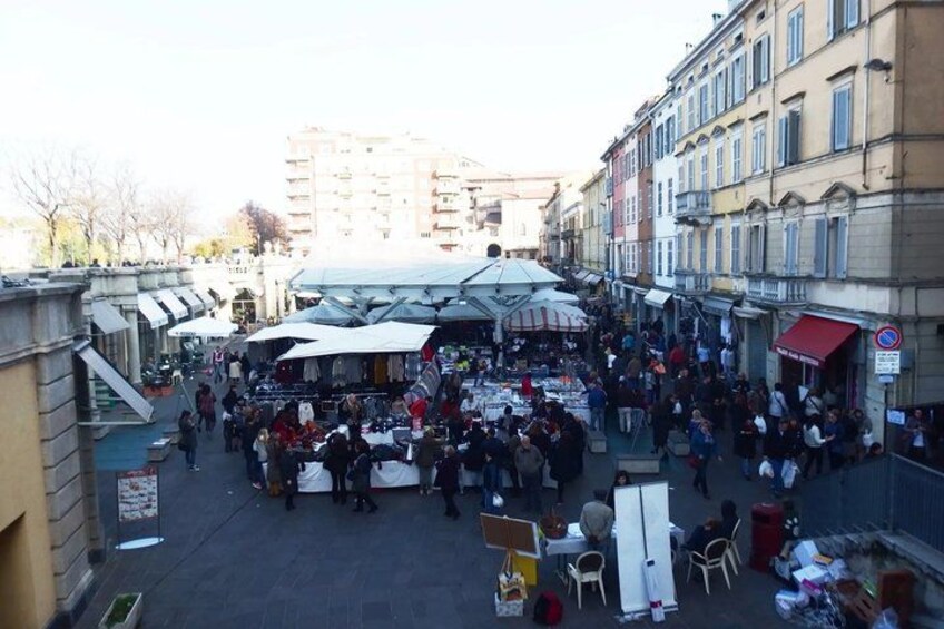 An outdoor market with vendors and customers. 2