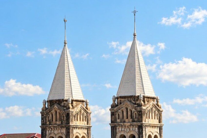 Two identical church towers with pointed roofs and crosses on top, set against a clear blue sky. 5