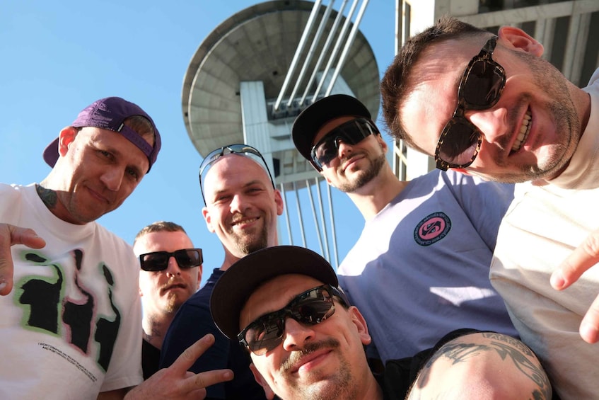A group of people posing with a satellite dish in the background. 1