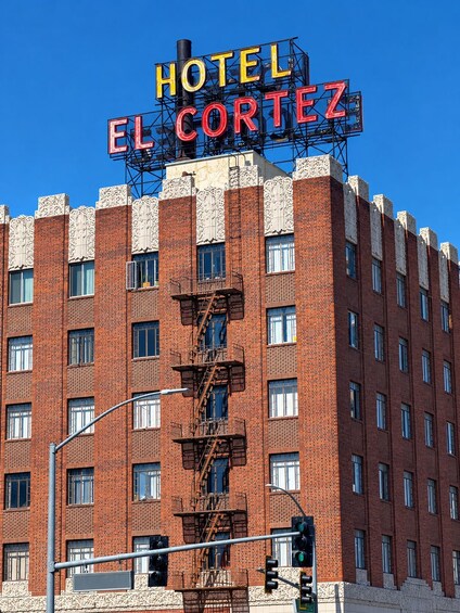 A hotel named 'Hotel El Cortez' with a distinctive red brick facade and ornate white detailing. 2