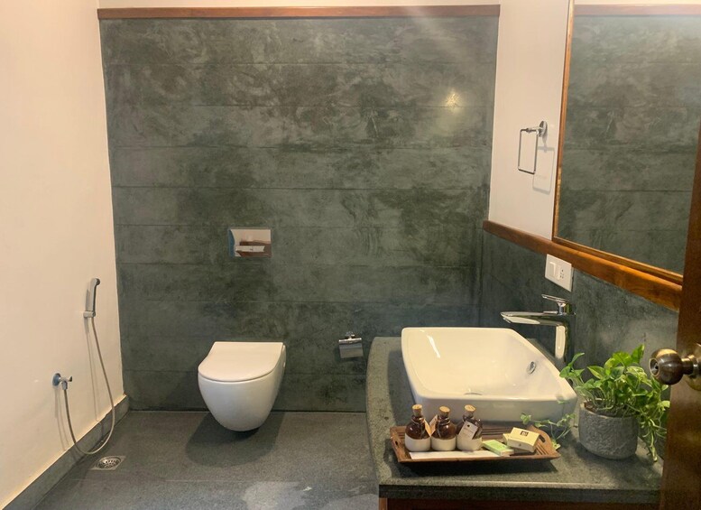 A modern bathroom with a white toilet, a white sink, and a mirror. 5