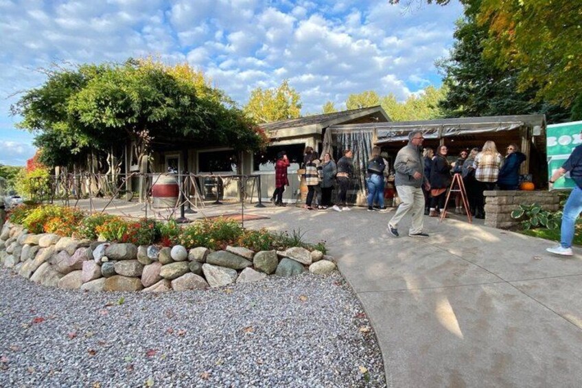 A building with a covered outdoor area, surrounded by a stone wall and gravel path. 5