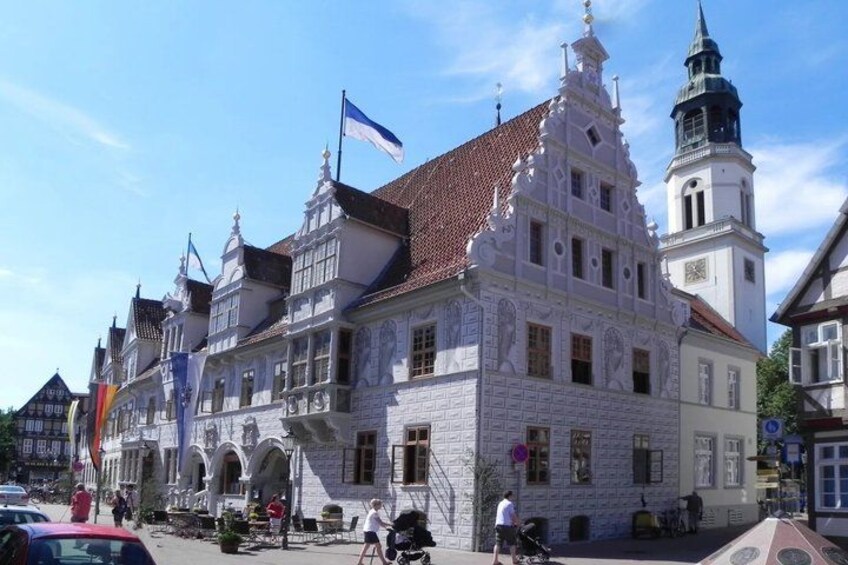 A historic building with ornate architecture, a clock tower, and flags. 2