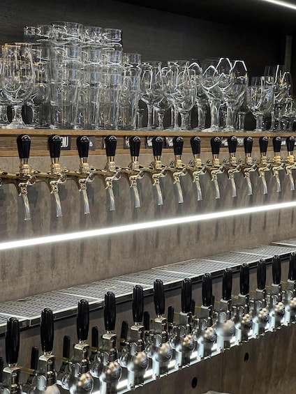 A bar with multiple taps and a variety of glassware. 3