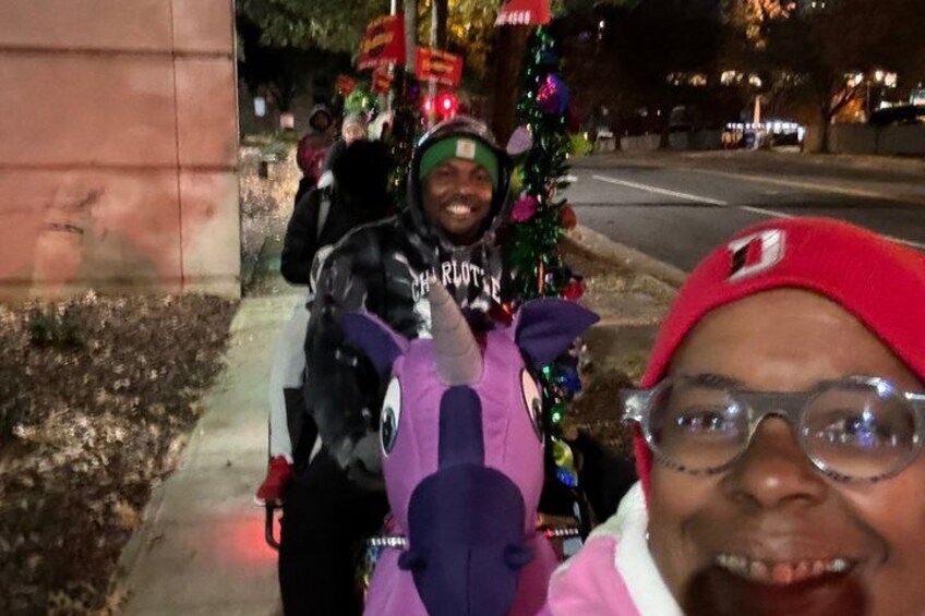 A person in a red hat and glasses, a purple unicorn toy, and a person in a black jacket with a helmet. 2