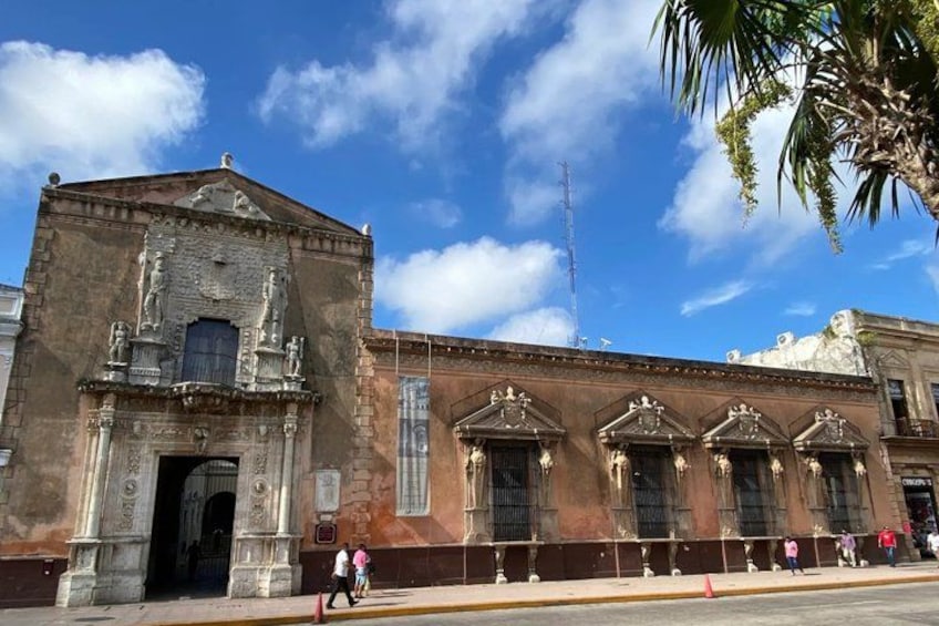 A historic building with ornate architecture, including a central doorway and decorative columns. 2