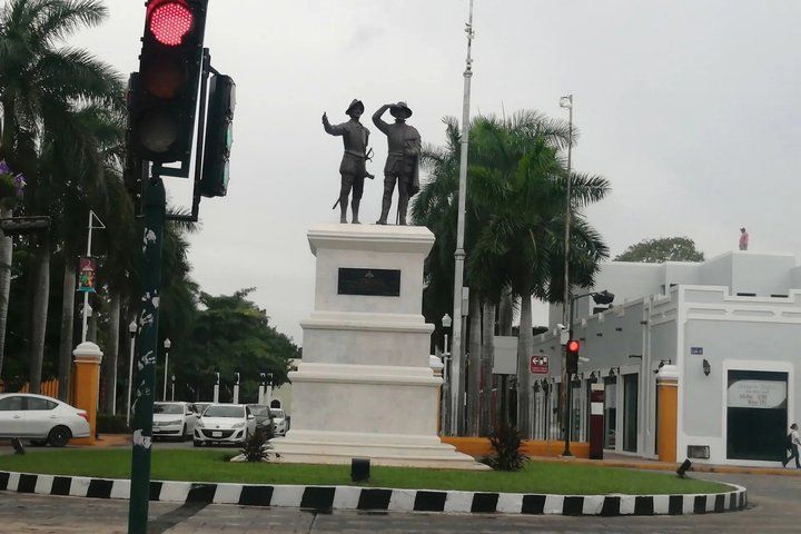 A traffic light, a statue, a palm tree, a building, and a car. 4