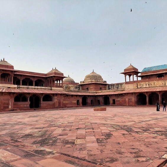 A historical building with domed structures and arched walkways. 3