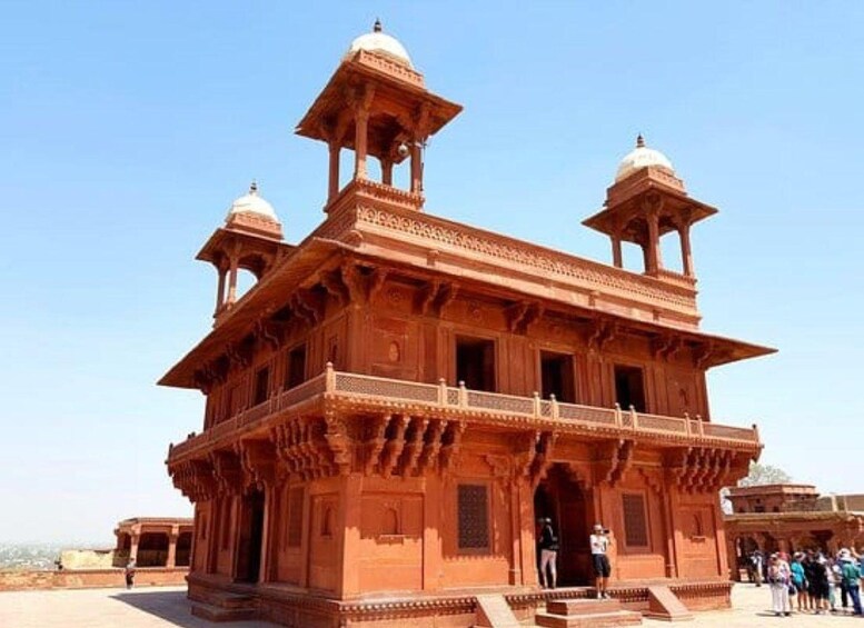 A large, ornate building with multiple domes and a balcony. 5
