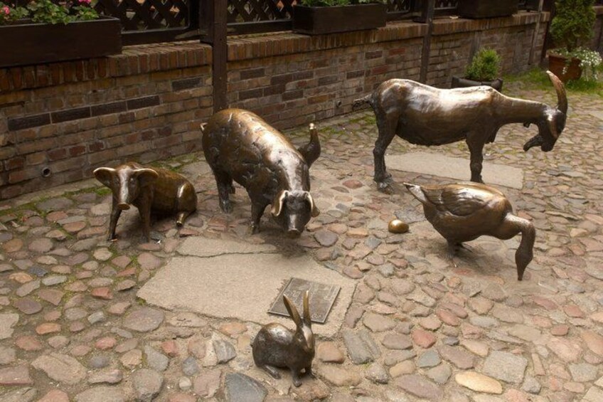 A stone-paved area with bronze animal sculptures. 4
